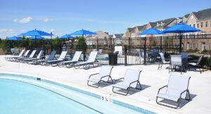 lounge chairs and blue umbrellas by the pool