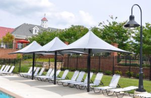 a row of lounge chairs and three standing umbrellas