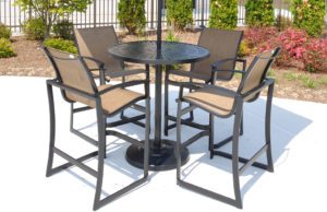 four brown outdoor chairs around a table with umbrella