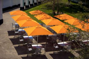chairs and tables with orange umbrellas