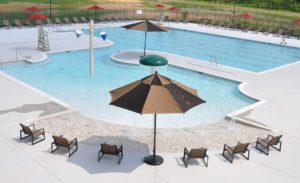 lounge chairs and umbrellas by a large swimming pool