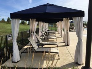 lounge chairs under blue and white gazebo tents