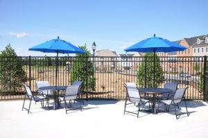 two sets of chairs and tables with blue umbrella