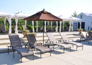 four lounge chairs and a standing umbrella in the middle