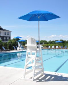 white high-chair with a blue umbrella by the pool