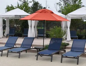 lounge chairs and table with red umbrella