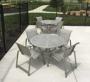 two round outdoor tables with four chairs each