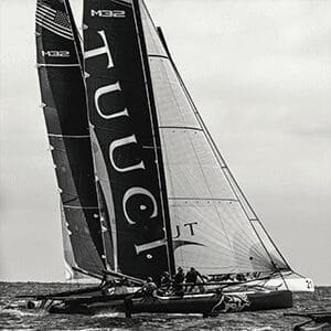 A black and white photo of a sail boat in the ocean.
